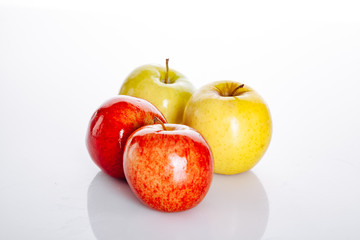 Red and yellow apples on white background with beautiful reflection