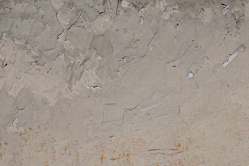 .Plastered wall of an old house with traces of weathering. Uneven gray surface. Grunge. Texture. Background. Copy space.