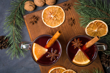Christmas hot mulled wine with cardamom, cinnamon and anise on wooden background. against the...