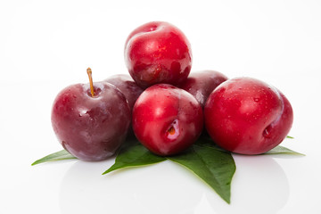 plums with plum leaves isolated on a white background