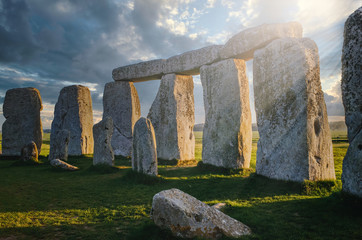 Inside the circle of stones at Stonehenge with the morning sun casting rays through the rock