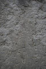 Ausschnitt eines verwitterten jüdischen Grabsteins mit Fragmenten der deutschen Inschrift
