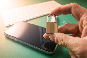 Young man holds a metal lock in his hands, protecting information