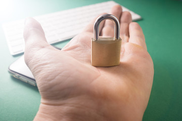 Young man holds a metal lock in his hands, information protection concept