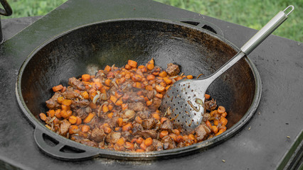Cooking in a cauldron in the yard. Kazan. Pilaf. Cooking in a cauldron. Street food. Oven for cauldron