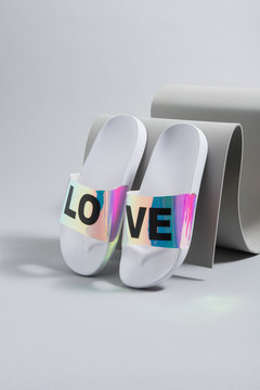 Chanclas de mujer modernas sobre objetos grises y fondo gris para pintar en diferentes colores, para cat&aacute;logo de zapatos