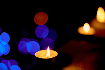 Candle burns on the background of Christmas decorations