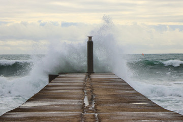 big ocean wave hit in a jetty in a stormy day