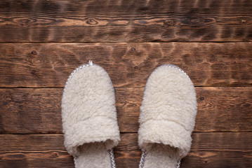 Fototapeta na wymiar Woolen slippers on the wooden floor of the hallway background.