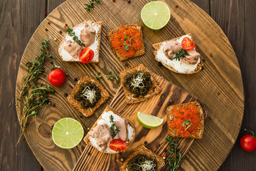 tasty snacks with cod liver with tomato