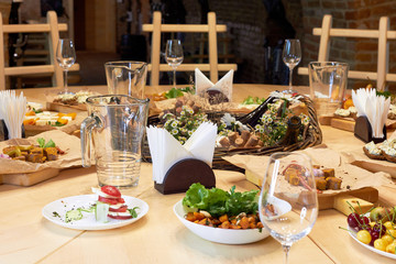 Served wooden table with a set of variety snacks, different vegetable salads, salad, pickle carrot, kavarma, rye bread sandwiches with soft cheese cream, fruits,