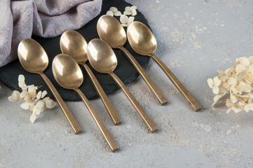 Old bronze tea spoons on concrete