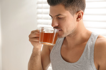 Fototapeta premium Man with cup of tea near window. Lazy morning