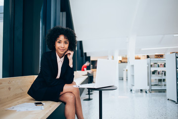 Portrait of female lawyer in trendy formal wear working on modern computer looking at camera, confident businesswoman spending time for research information on banking website using 4G internet