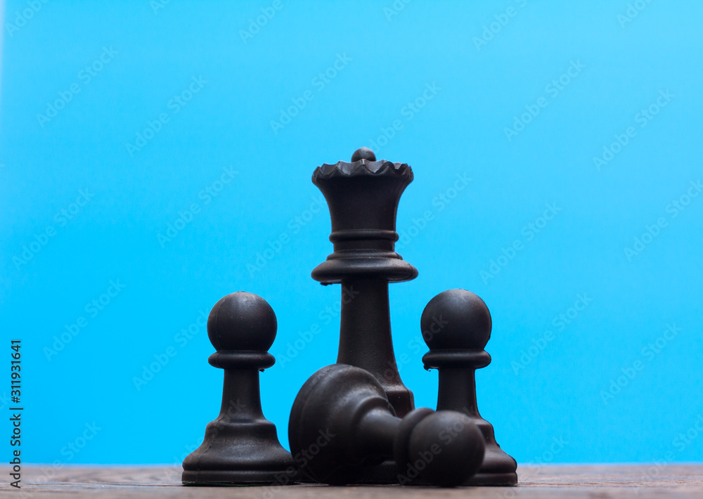 Wall mural Black chess on wood with blue background,leadership conceptual