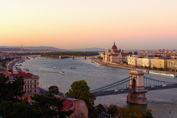 Fototapeta na wymiar Autumn sunset in Budapest. Aerial cityscape view. Bridges over Danube River, picturesque embankment with medieval The Hungarian Parliament. Famous touristic place and travel destination in Europe