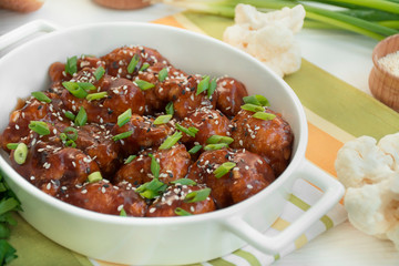 Fried Cauliflower in Sauce and Sesame. Asian style dish. White wood background. Space for text. Flat lay.