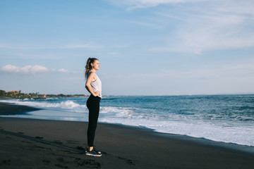 Young woman in sportswear against sky and sea