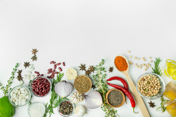 Cooking background, herbs, salt, spices, olive oil, white background copy space. View from above. Healthy food concept with fresh vegetables and cooking ingredients. Table background menu.