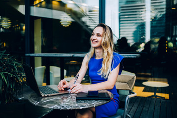Fototapeta premium Positive freelancer with laptop in cafe