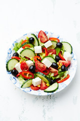 Healthy salad with feta cheese, black olives, cherry tomatoes, cucumber and red pepper. Close up.