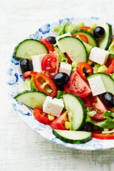 Healthy salad with feta cheese, black olives, cherry tomatoes, cucumber and red pepper. Close up.
