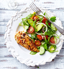 Spicy chicken breast with cherry tomatoes, cucumber and rocket on white wooden background. Top view. 
