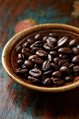 Coffee beans on rustic wooden background. Close up. 