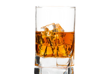 A glass of whiskey with ice or brandy and a square carafe isolated on a white background. Whiskey with ice in a glass against white background.