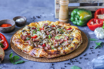 Photo of pizza on the table with ingredients around. Tasty pizza on the wooden background. Homemade pizza. Italian pizza. Delicious pizza. Image