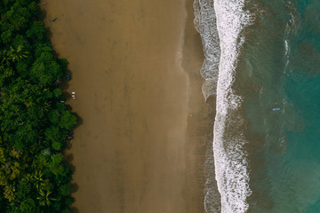 Aerial Drone View of a tropical beach in Costa Rica. Sand and water surrounded by lush rainforest