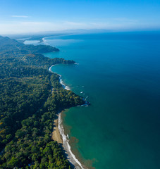 Fototapeta na wymiar Aerial Drone View of a tropical beach in Costa Rica. Sand and water surrounded by lush rainforest