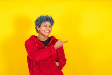 afro american woman isolated on color background pointing by hand