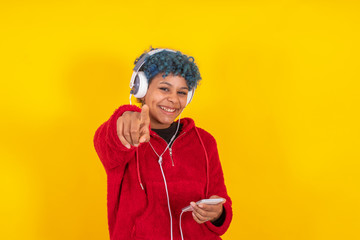 afro american girl with mobile phone and headphones on yellow background