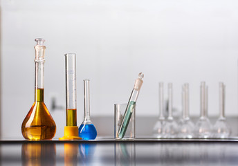A set of jars and flasks with colored reagent solutions in a real laboratory. Large light empty...