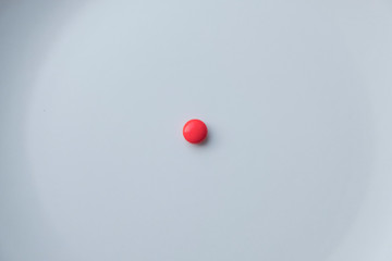 Red minimalistic pill on white background