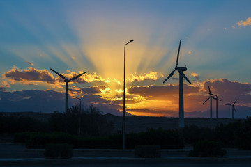 Obraz premium Sunset over wind turbines.