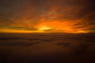 Beautiful sunrise cloudy sky from aerial view. Airplane view above clouds