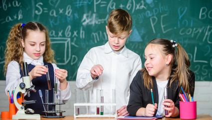 Girls and boy student conduct school experiment with liquids. School laboratory. Group school pupils study chemical liquids. School chemistry lesson. Test tubes with substances. Formal education