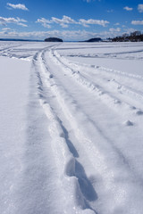Fototapeta na wymiar winter scene of ski tracks in snow on frozen lake