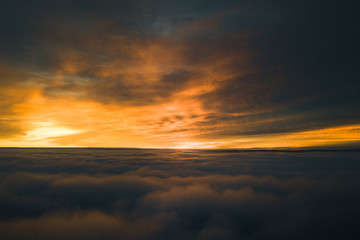 Fototapeta na wymiar Beautiful sunrise cloudy sky from aerial view. Airplane view above clouds