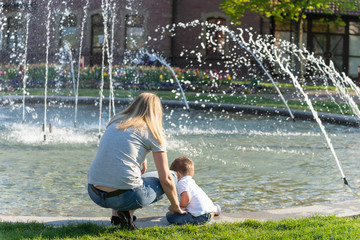 Mutter mit kleinem Kind am Springbrunnen