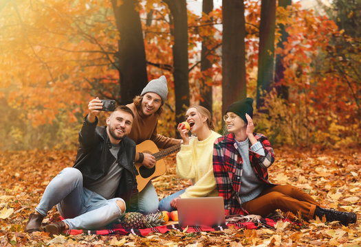 Happy young friends taking selfie in autumn park - Powered by Adobe