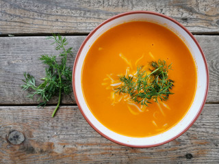Tomato soup in a bowl, with grated cheese and dill