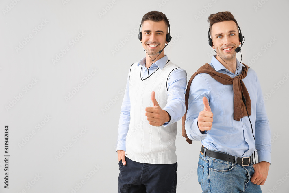 Poster team of technical support agents showing thumb-up gesture on light background