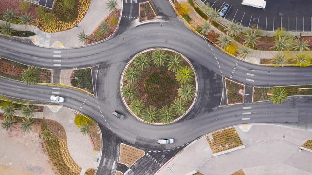 Aerial timelapse of cars driving in a traffic circle roundabout in USA suburban