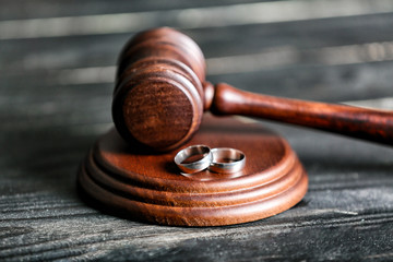 Judge's gavel and rings on wooden background. Concept of divorce - obrazy, fototapety, plakaty