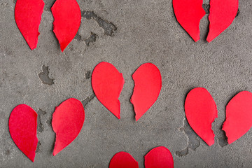 Many broken hearts on grey background. Concept of divorce