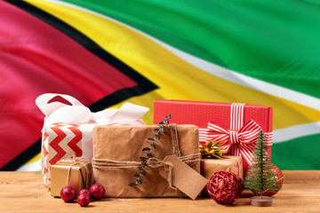 Guyana new year celebration theme. Wrapped christmas gifts on waving national flag background. Merry christmas concept.