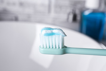 Fototapeta na wymiar Tooth brush with paste in bathroom, closeup